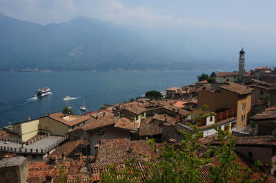 High angle view of townscape by sea against sky