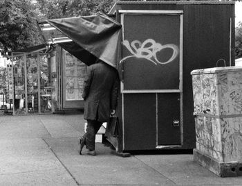 Rear view of man leaning on stall