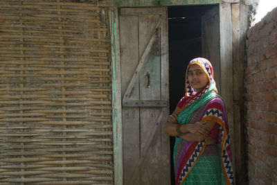 Portrait indian of woman wearing sari standing against door