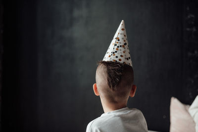 Rear view of boy looking at camera