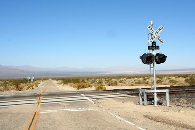 Road signs on landscape against clear sky