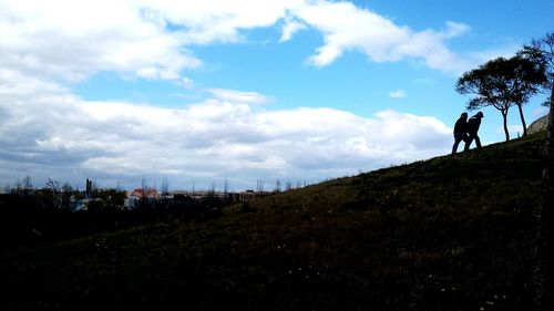 Silhouette of trees against cloudy sky