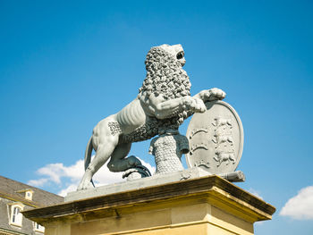 Low angle view of statue against blue sky