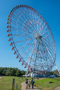 Low angle view of ferris wheel against clear blue sky