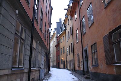 Alley amidst buildings in winter