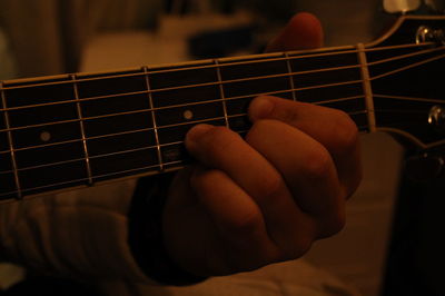 Midsection of man playing guitar