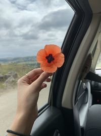 Midsection of person holding umbrella against sky