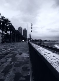 Street by pier against sky in city