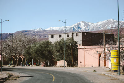 Street amidst buildings against clear sky