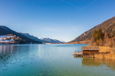 Scenic view of lake and mountains against blue sky