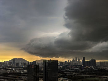 Panoramic view of buildings in city against storm clouds