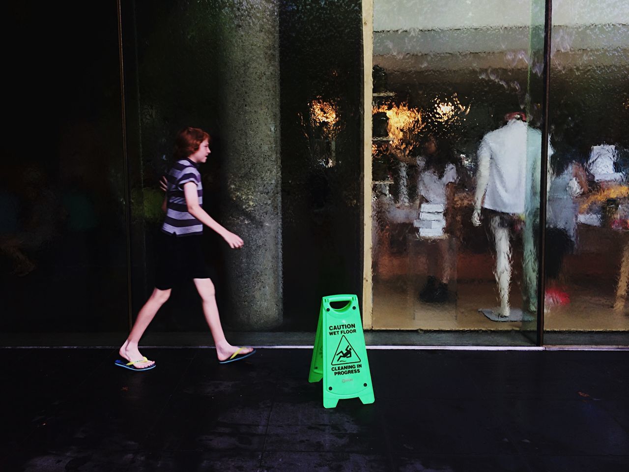 standing, communication, indoors, full length, text, lifestyles, wall - building feature, casual clothing, western script, door, protection, glass - material, street, side view, day, front view, closed, wall