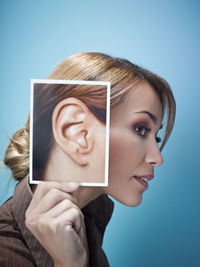 Side view of woman holding photograph