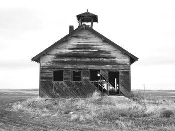 Old house on field against sky