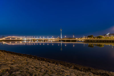 Illuminated bridge over river at night