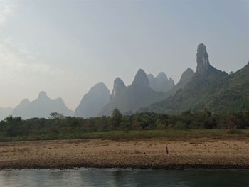 Scenic view of river and mountains against sky