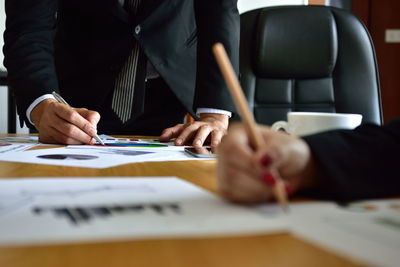 Cropped image of business colleagues working on table