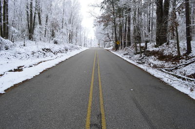 Empty road along snow covered landscape