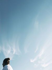 Low angle view of woman against blue sky