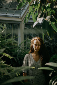 Front view of a young woman amidst plants during sunset