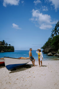 Women on beach against sky