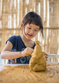 Girl looking away while sitting on table