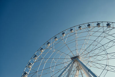 Low angle view of ferris wheel against blue sky