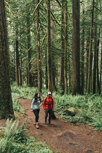 A young couple enjoys a hike on a trail in the pacific northwest.