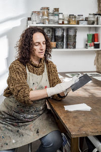 Female artist preparing a plate for an art print.