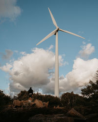 Low angle view of windmill on field against sky