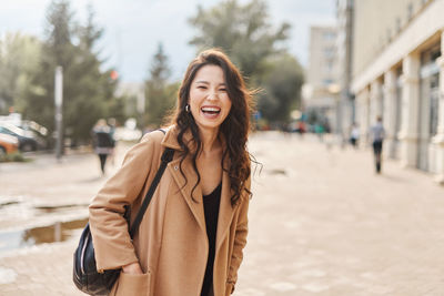 Portrait of young woman standing in city