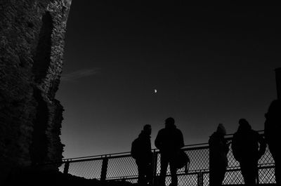 Low angle view of silhouette people against clear sky