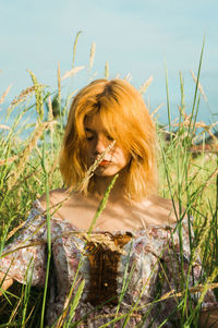 Woman looking away while relaxing on field