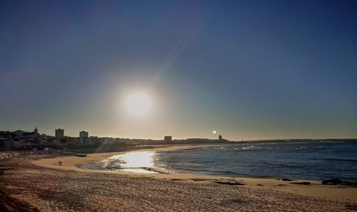 Scenic view of beach against clear sky during sunset