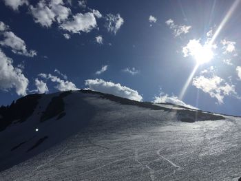 Sun shining over snow covered landscape