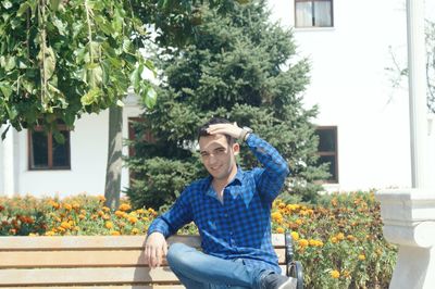 Portrait of smiling young man sitting on bench