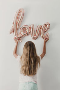 Rear view of woman standing against white background