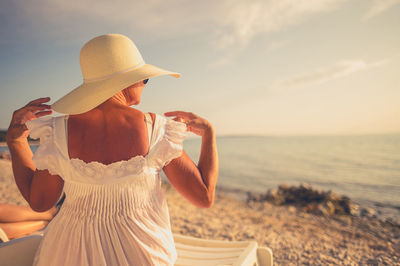 Woman looking at sea against sky