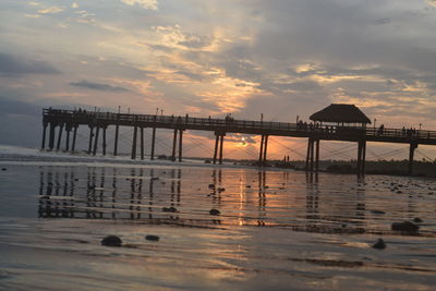 Pier on sea at sunset