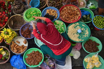 High angle view of woman with vegetables for sale at market stall