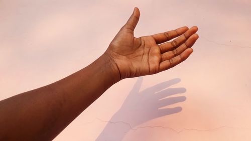 Close-up of hand against sky