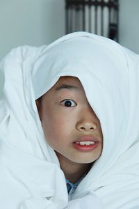 Portrait of teenage boy wrapped in blanket