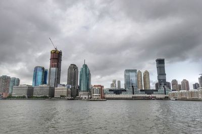 View of buildings in city against cloudy sky