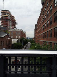 Buildings in city against cloudy sky