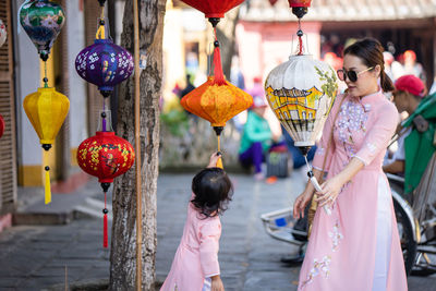 Mother and daughter looking at paper lamp at market in hoi an.