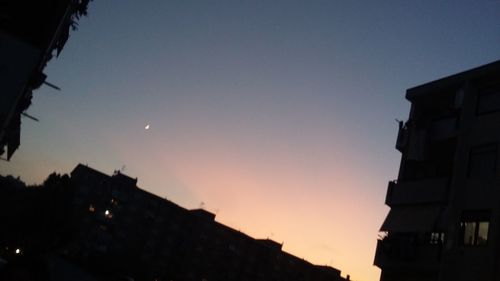 Low angle view of silhouette buildings against sky during sunset