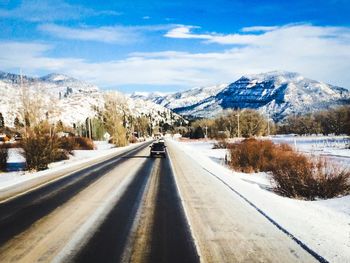 Empty road in snow covered landscape