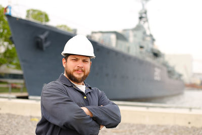 Portrait of sailor standing against ship