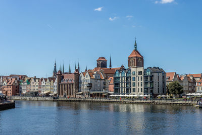 River amidst buildings in city against sky