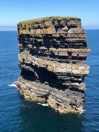 View of rock formation in sea against sky